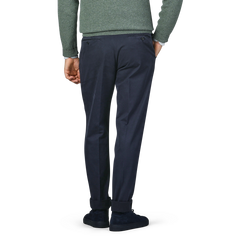 A person in a green sweater and Incotex Navy Blue Cotton Twill Regular Chinos is standing with their back to the camera.