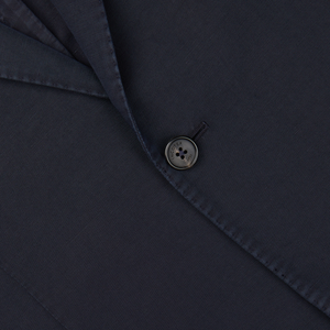 Close-up of a dark button sewn onto Slowear's Navy Blue Washed Chinolino Suit fabric with a visible seam.