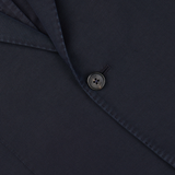 Close-up of a dark button sewn onto Slowear's Navy Blue Washed Chinolino Suit fabric with a visible seam.