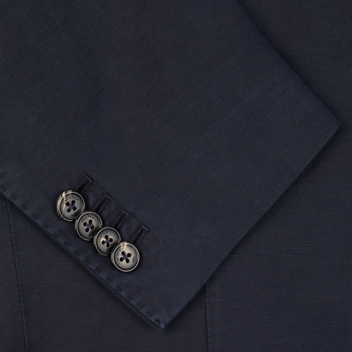 Detail of a Slowear navy blue washed chinolino suit jacket sleeve with four buttons.