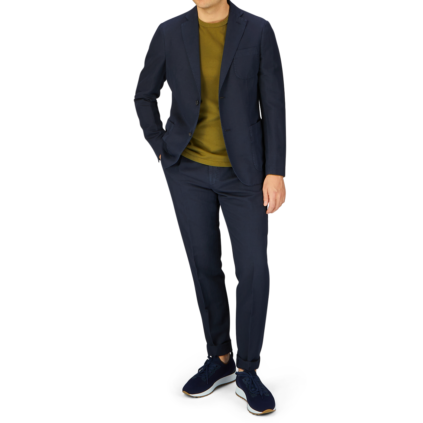A man in a smart-casual attire featuring a Slowear Navy Blue Washed Chinolino Suit in a regular fit, made from a linen-cotton blend, paired with blue sneakers.