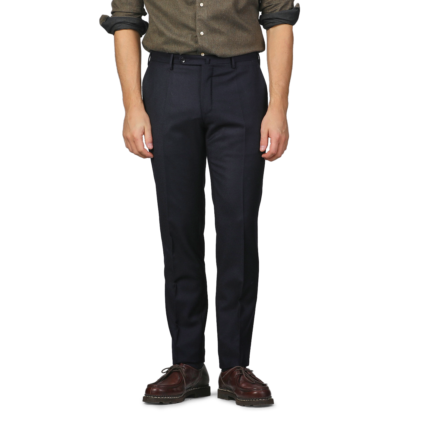 A man dressed in Incotex Navy Blue Wool Flannel Slim Trousers, a brown shirt, and brown shoes stands with his arms by his sides against a plain background. The slim fit of the trousers highlights his relaxed yet refined stance.