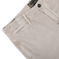 Close-up of Incotex's Taupe Beige Cotton Corduroy Regular Fit Trousers, showcasing a visible button and waistband, along with belt loops and a pocket slit.