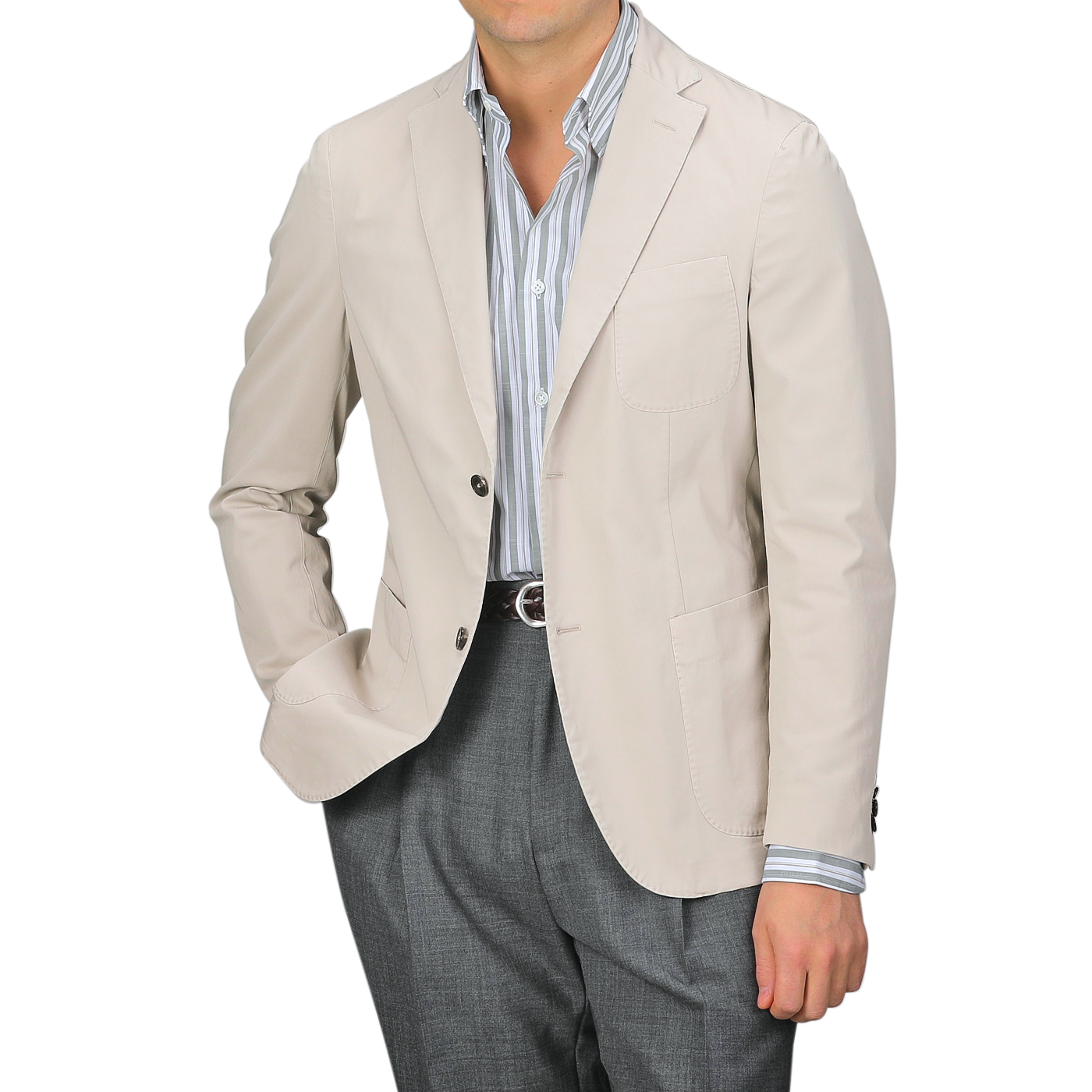 A man wears an Incotex Taupe Beige Washed Cotton Batavia Blazer over a striped shirt and gray trousers, shown from shoulders to waist. The unstructured blazer offers a relaxed yet polished style, showcasing the ensemble's versatility and modern appeal.