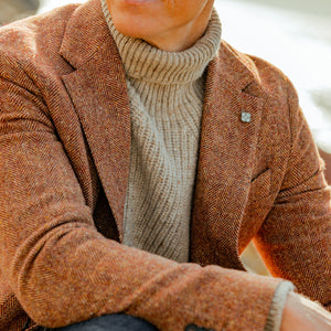A man wearing an Inis Meain Beige Melange Wool Cashmere Boatbuilder Rollneck.