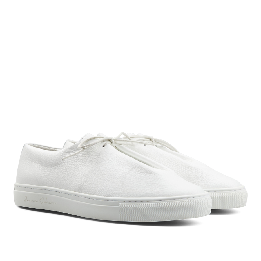 A pair of contemporary White Grained Leather Jim sneakers by Jacques Soloviére Paris on a white background.