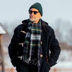 A man wearing a Johnstons Of Elgin Navy Checked Dress Gordon Cashmere Scarf.