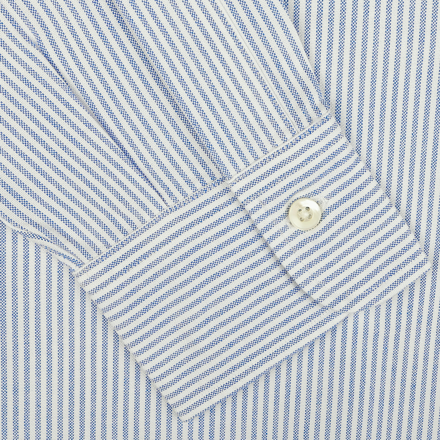 Close-up of a sleeve from the Blue Striped Washed Cotton Oxford BD Shirt by Kamakura Shirts, showcasing pure cotton oxford fabric in blue and white stripes with a buttoned cuff.