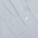 Close-up of a sleeve from the Blue Striped Washed Cotton Oxford BD Shirt by Kamakura Shirts, showcasing pure cotton oxford fabric in blue and white stripes with a buttoned cuff.