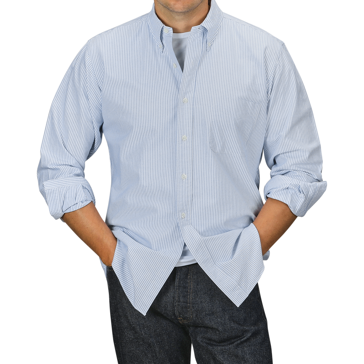 Person wearing a Kamakura Shirts Blue Striped Washed Cotton Oxford BD Shirt over a white t-shirt, with hands in the pockets of dark jeans against a gray background.