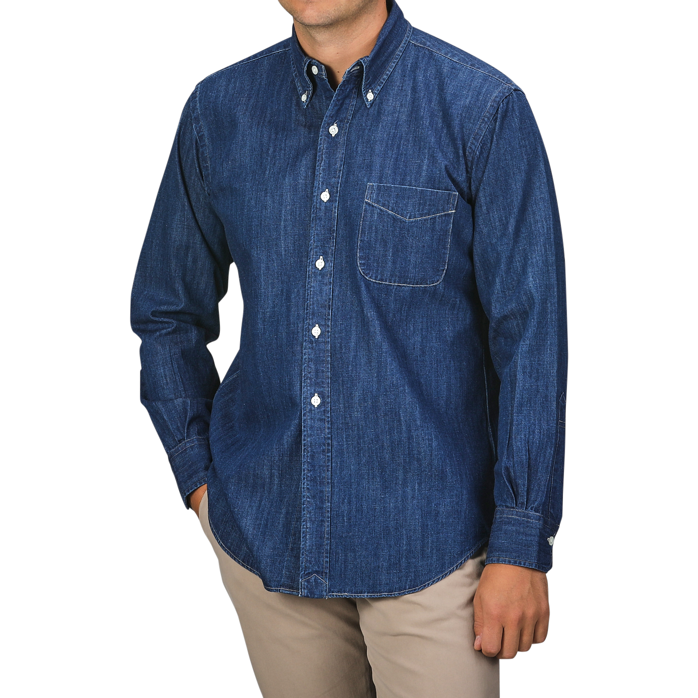 A person wearing a Kamakura Shirts Dark Blue Japanese Denim 7oz BD Shirt, featuring a button-down collar and front pocket, paired with beige pants. The person's face is not visible.