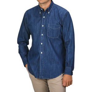 A person wearing a Kamakura Shirts Dark Blue Japanese Denim 7oz BD Shirt, featuring a button-down collar and front pocket, paired with beige pants. The person's face is not visible.