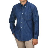 A person wearing a Kamakura Shirts Dark Blue Japanese Denim 7oz BD Shirt, featuring a button-down collar and front pocket, paired with beige pants. The person's face is not visible.