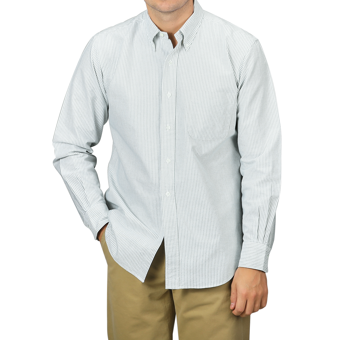 A person wearing a Green Striped Washed Cotton Oxford BD Shirt from Kamakura Shirts and khaki pants, showcasing a classic button-down collar, stands with one hand in their pocket against a plain background.