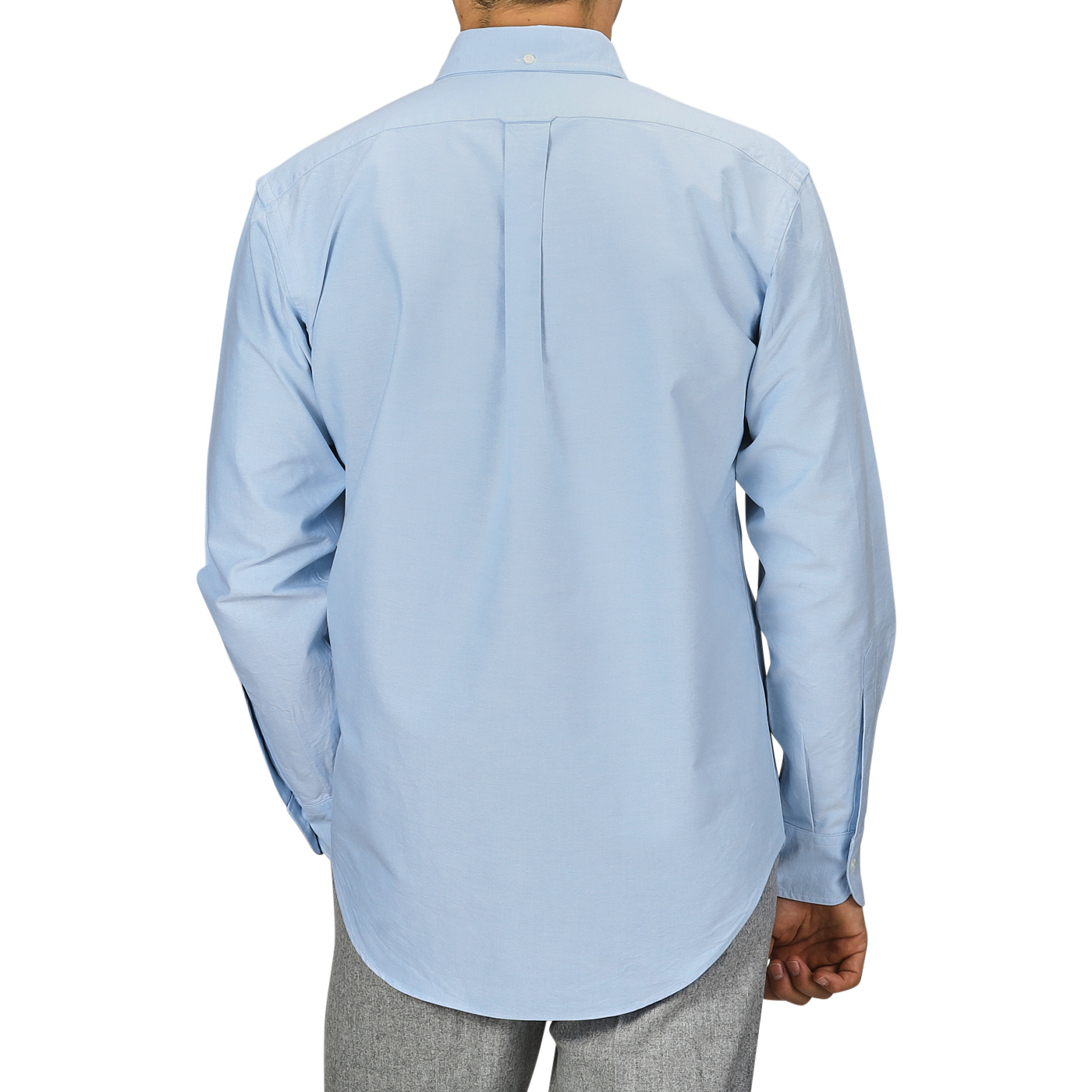 A man is seen from the back wearing a light blue Kamakura Shirts' Washed Cotton Oxford BD Shirt paired with grey trousers, set against a plain background.