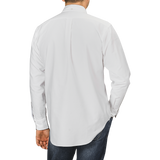 A person is shown from the back wearing a White Washed Cotton Oxford BD Shirt by Kamakura Shirts and dark jeans, with the left hand tucked in the pocket of the jeans.