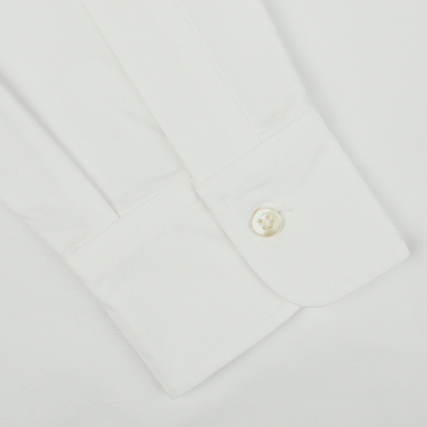 Close-up of the White Washed Cotton Oxford BD Shirt cuff by Kamakura Shirts with a single white button fastened, highlighting the pure cotton oxford texture from our Vintage Ivy collection.