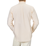 Back view of a person wearing the Yellow Striped Washed Cotton Oxford BD Shirt by Kamakura Shirts, paired with white pants, standing against a neutral background.