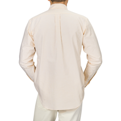 Back view of a person wearing the Yellow Striped Washed Cotton Oxford BD Shirt by Kamakura Shirts, paired with white pants, standing against a neutral background.