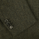 Close-up of L.B.M. 1911's Dark Green Wool Cashmere Herringbone Blazer, showcasing the luxurious herringbone-patterned fabric in shades of dark brown and black, adorned with four black buttons sewn into it.