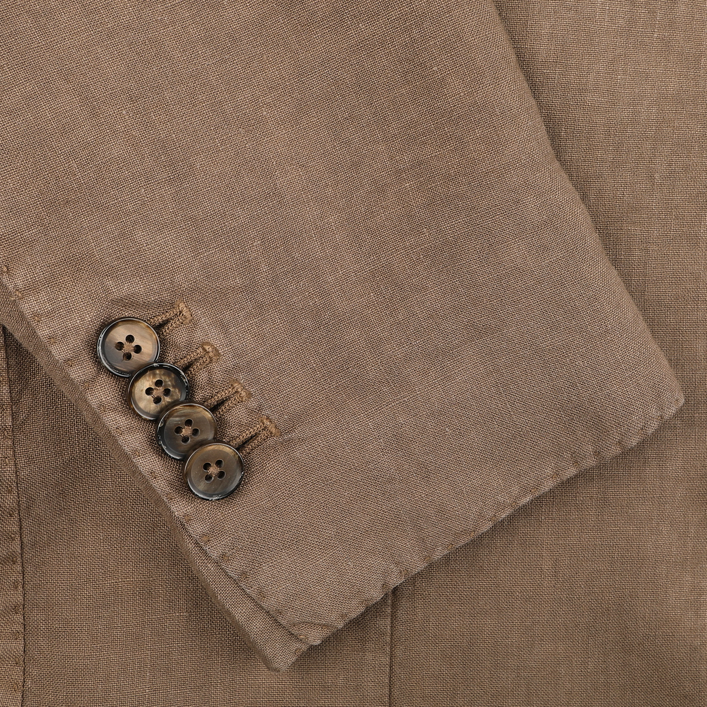 Close-up of a Light Brown Washed Linen Blazer sleeve by L.B.M. 1911, showcasing four elegant brown buttons.