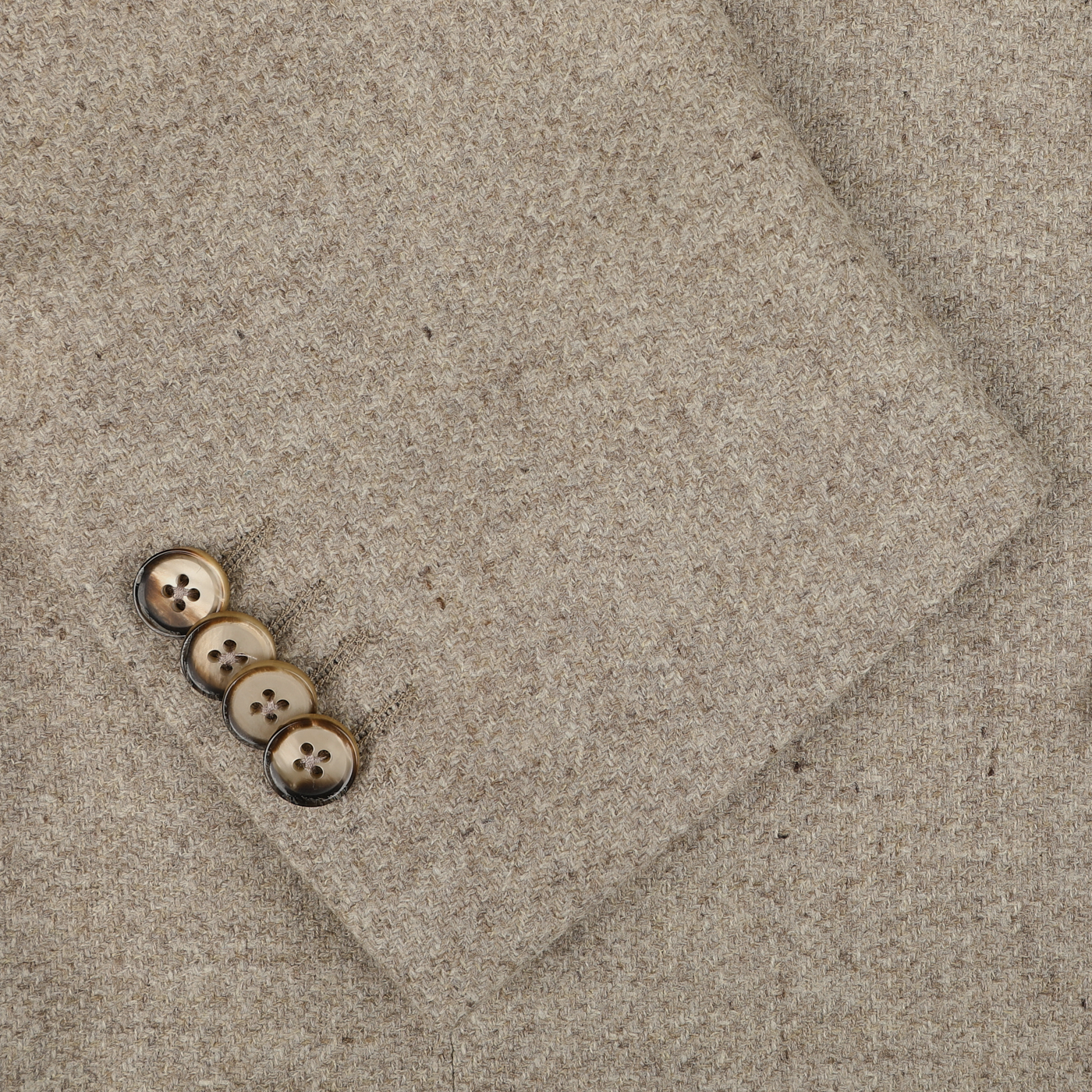 Close-up of an Oatmel Beige Shetland Wool Cashmere Blazer sleeve by L.B.M. 1911, featuring four neatly aligned brown buttons.