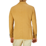 Rear view of a person wearing a Dark Beige Washed Cotton Linen Blazer by L.B.M. 1911 with a straight seam down the back.