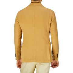 Rear view of a person wearing a Dark Beige Washed Cotton Linen Blazer by L.B.M. 1911 with a straight seam down the back.