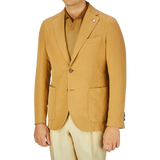 A man wearing a L.B.M. 1911 Dark Beige Washed Cotton Linen Blazer with a lapel pin over a light-colored shirt, paired with cream pants.