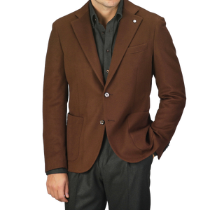 A person wearing the L.B.M. 1911 Tobacco Brown Brushed Wool Slim Blazer, made from pure virgin wool, over a dark shirt and dark pants, standing against a plain background.