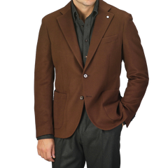 A person wearing the L.B.M. 1911 Tobacco Brown Brushed Wool Slim Blazer, made from pure virgin wool, over a dark shirt and dark pants, standing against a plain background.