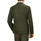 A man is shown from the back wearing an L.B.M. 1911 Dark Green Wool Cashmere Herringbone Blazer, in a slim fit, paired with khaki pants.