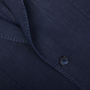 Close-up of a dark, tailored L.B.M. 1911 Navy Blue Washed Linen Blazer jacket with a button.