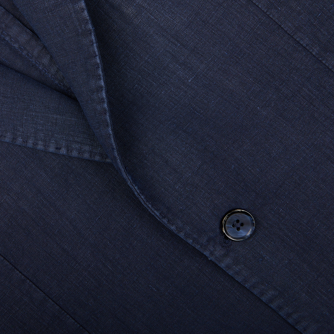 Close-up of a dark, tailored L.B.M. 1911 Navy Blue Washed Linen Blazer jacket with a button.