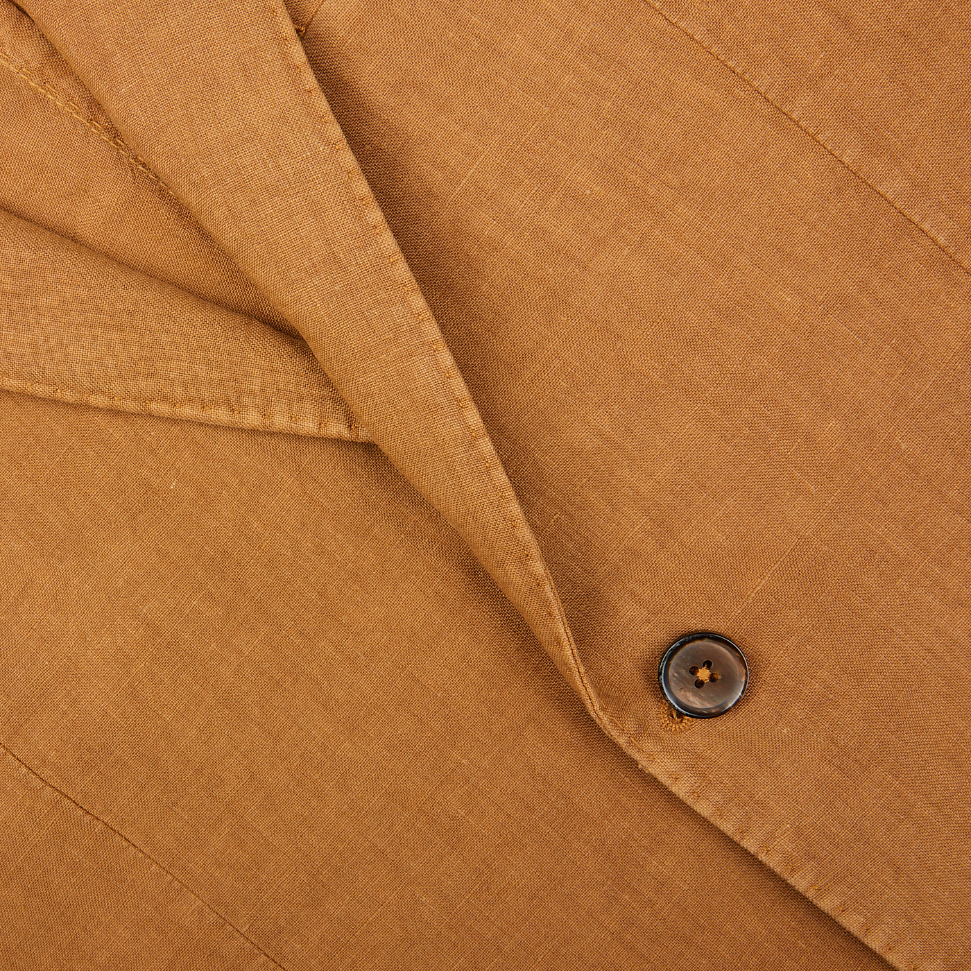 Close-up of a brown button on a L.B.M. 1911 Tobacco Brown Washed Linen Blazer.