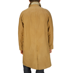 The back view of a man wearing a Dark Beige Waxed Cotton Kamikaze Trenchcoat by L'Impermeabile.