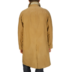 The back view of a man wearing a Dark Beige Waxed Cotton Kamikaze Trenchcoat by L'Impermeabile.