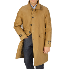 A man wearing a Dark Beige Waxed Cotton Kamikaze Trenchcoat by L'Impermeabile.