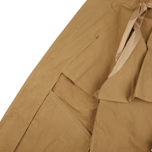 An image of a Dark Beige Waxed Cotton Kamikaze Trenchcoat by L'Impermeabile on a white surface.
