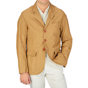 A man wearing a Camel Beige Waxed Linen College LL jacket by L'Impermeabile and white pants.