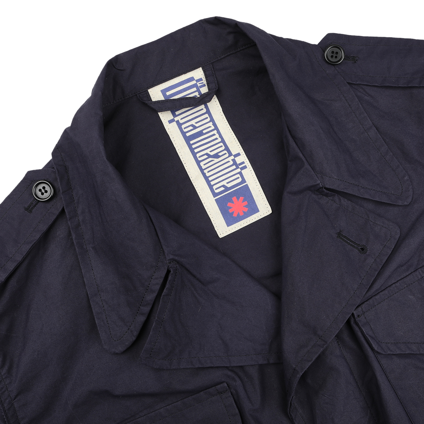 The Navy Blue Waxed Cotton Smith SFO Jacket by L'Impermeabile boasts a button-detailed collar and water-repellent finish. Inside, the label's stylized font and small red emblem enhance its unique appeal.