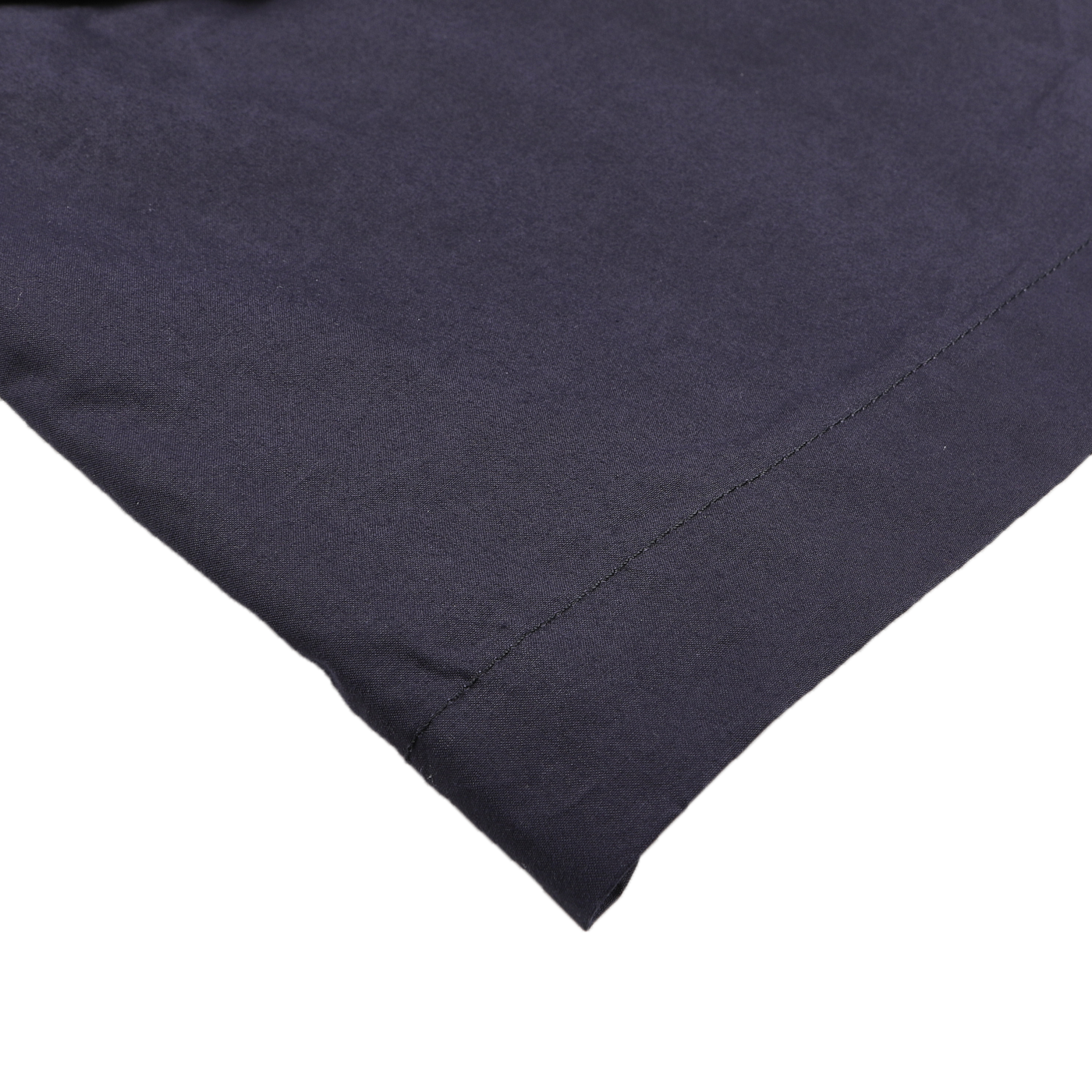 Close-up of a neatly folded Navy Blue Waxed Cotton Smith SFO Jacket by L'Impermeabile, showcasing the craftsmanship highlighted by a seam along one edge.