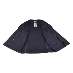 The L'Impermeabile Navy Blue Waxed Cotton Smith SFO Jacket rests open on a white surface, showcasing its interior lining and tags. This field jacket includes side pockets and offers water-repellent fabric for enhanced practicality.