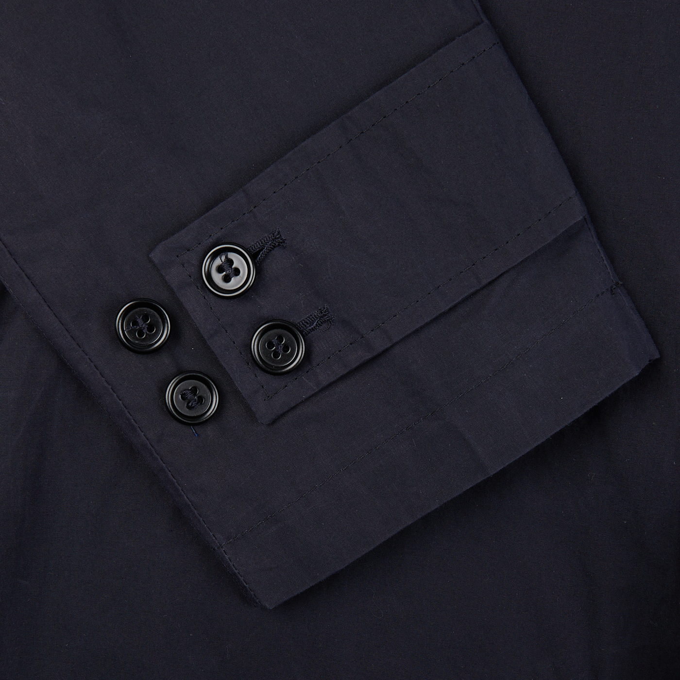 A close up image of L'Impermeabile Navy Blue Waxed Cotton Kamikaze Trenchcoat with buttons.