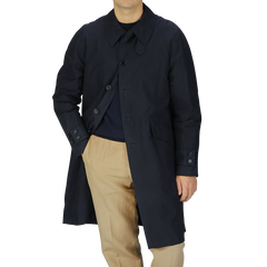 A man wearing a Navy Blue Waxed Cotton Kamikaze Trenchcoat and tan pants by L'Impermeabile.