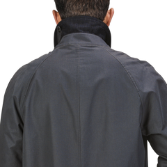 Back view of a person wearing a Washed Blue Waxed Cotton Kamikaze Coat from L'Impermeabile with the collar turned up.