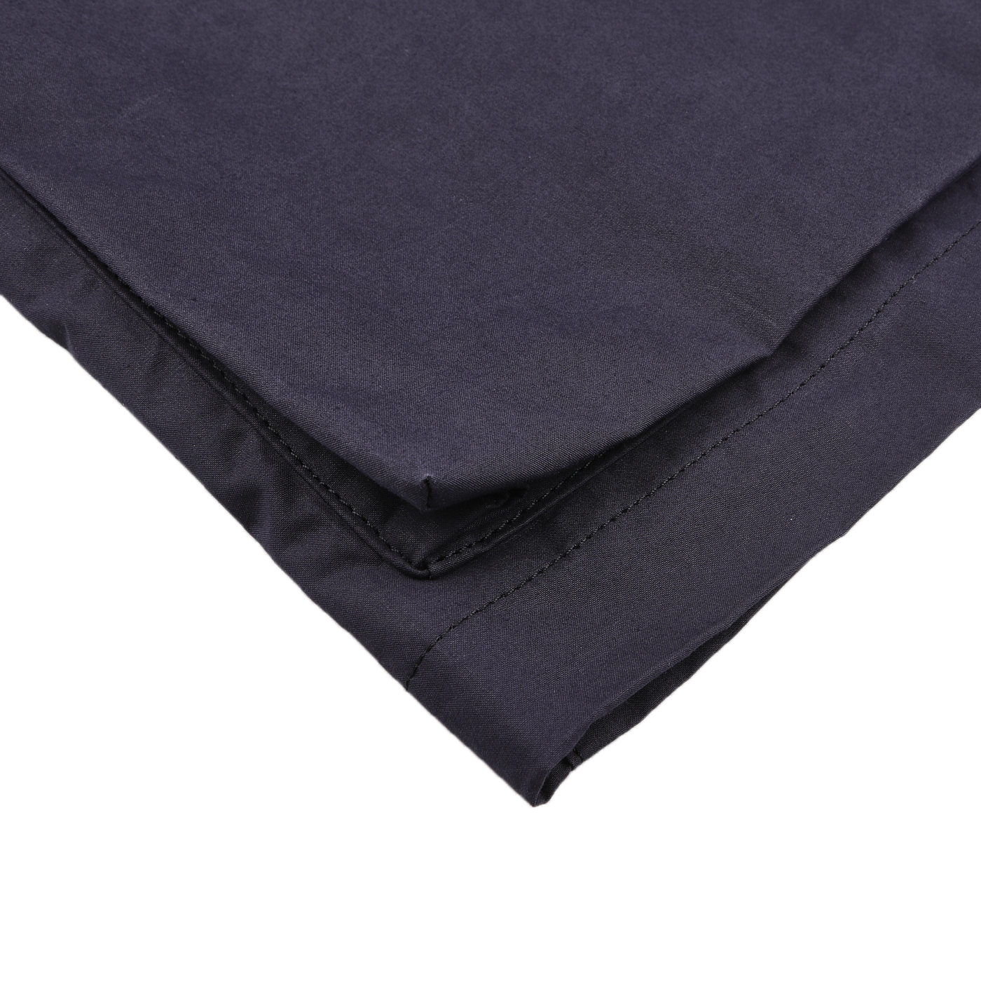 Close-up of neatly folded dark fabric, highlighting stitching details along one edge, reminiscent of the Navy Blue Waxed Cotton Bob Short Parka's precise craftsmanship by L'Impermeabile.