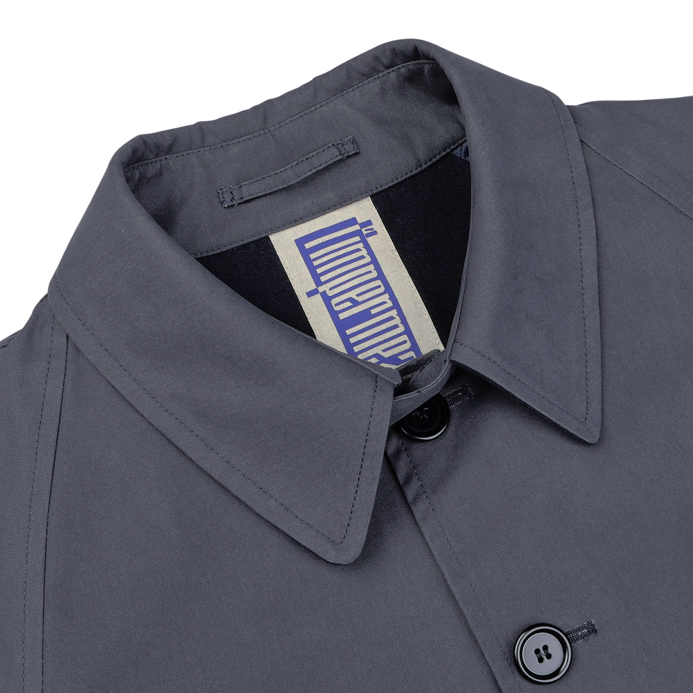 Close-up of the Washed Blue Waxed Cotton Kamikaze Coat by L'Impermeabile, showing a gray button-up shirt with a visible white tag near the collar displaying a vertical blue logo.