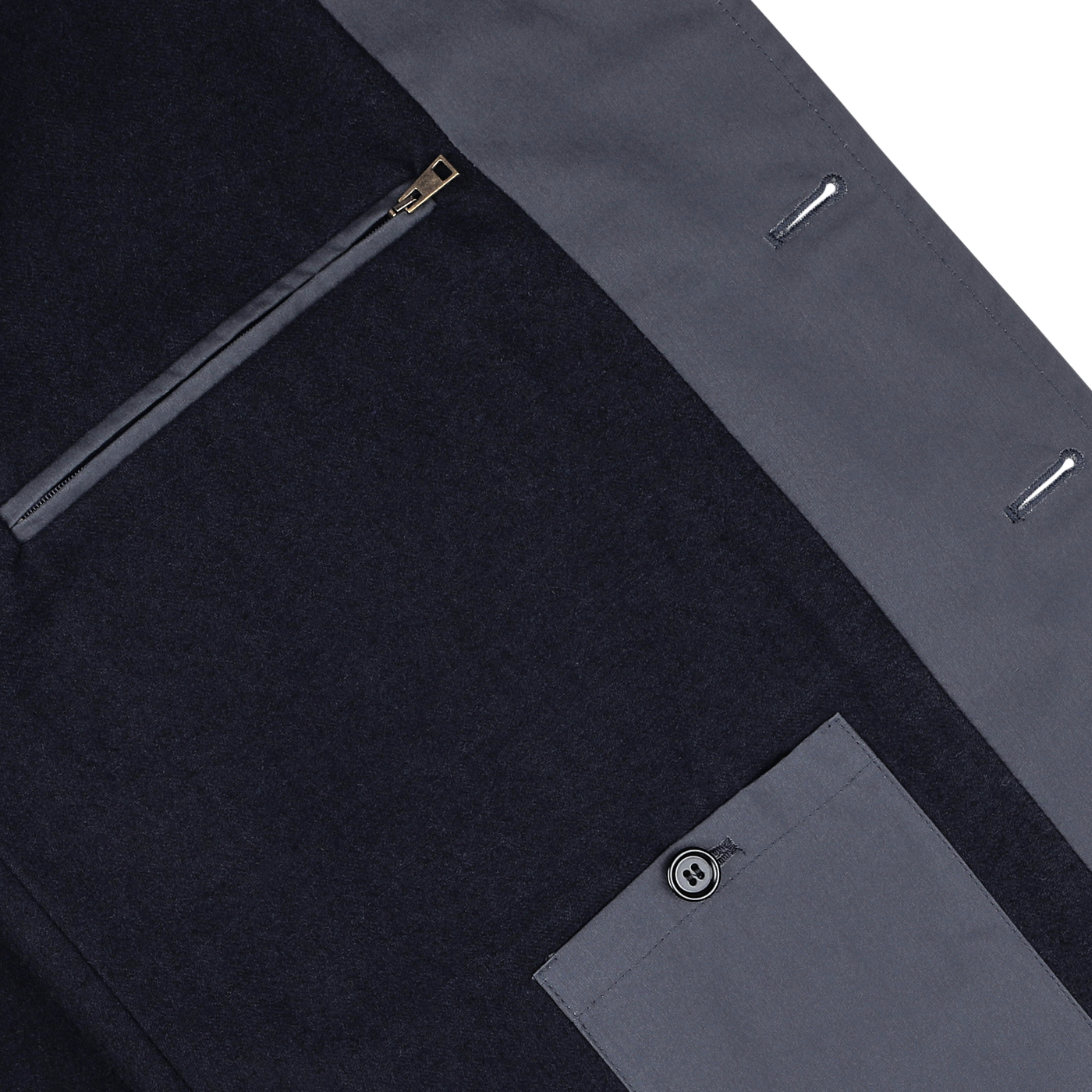 Close-up view of a L'Impermeabile Washed Blue Waxed Cotton Kamikaze Coat featuring a zippered pocket and an extra button sewn into the waxed cotton fabric.