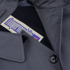 Close-up of a neck tag inside a Washed Blue Waxed Cotton Kamikaze Coat, showing a label with stylized text design from L'Impermeabile.